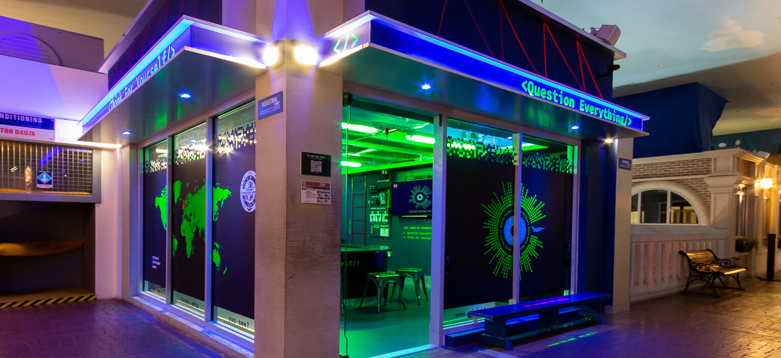 The CSA Immersive shopfront, lit up with blue and green neon signage reading Question Everything