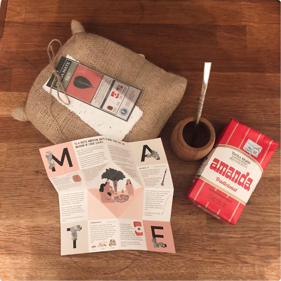 A flatlay of the burlap bag, leaflet, wooden gourd and a pack of yerba mate